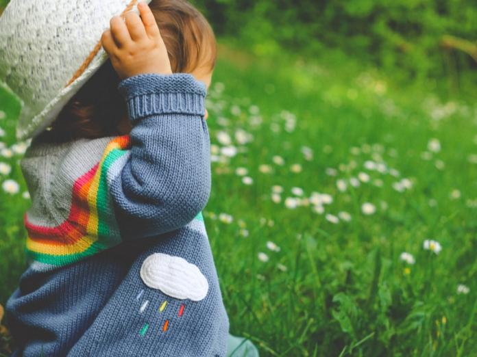 toddler with hat in a field